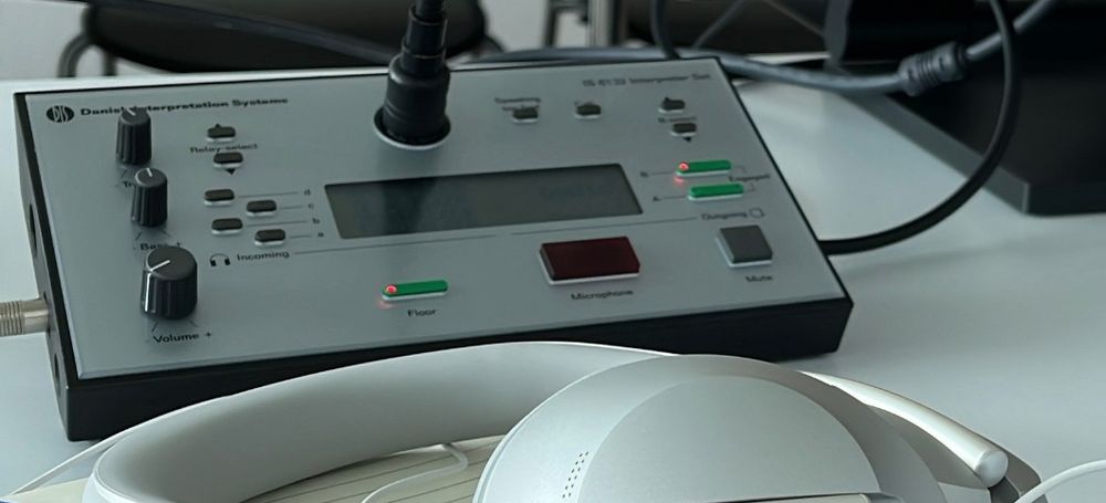 An interpreter console on a conference desk, with headphones in front of it
